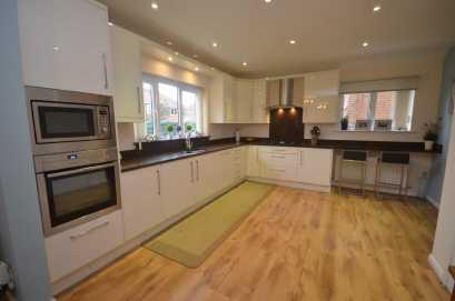 KITCHEN AREA Fitted with an attractive range of cream high gloss fronted base and wall level units incorporating drawers and cupboards with granite worktops and a small breakfast bar area with
