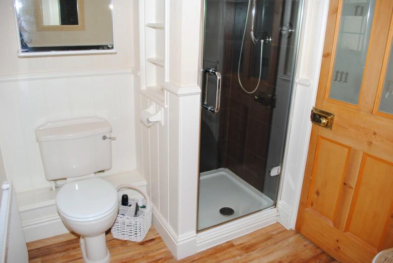 Tiled splashbacks complement the suite comprising a timber panelled bath, pedestal wash