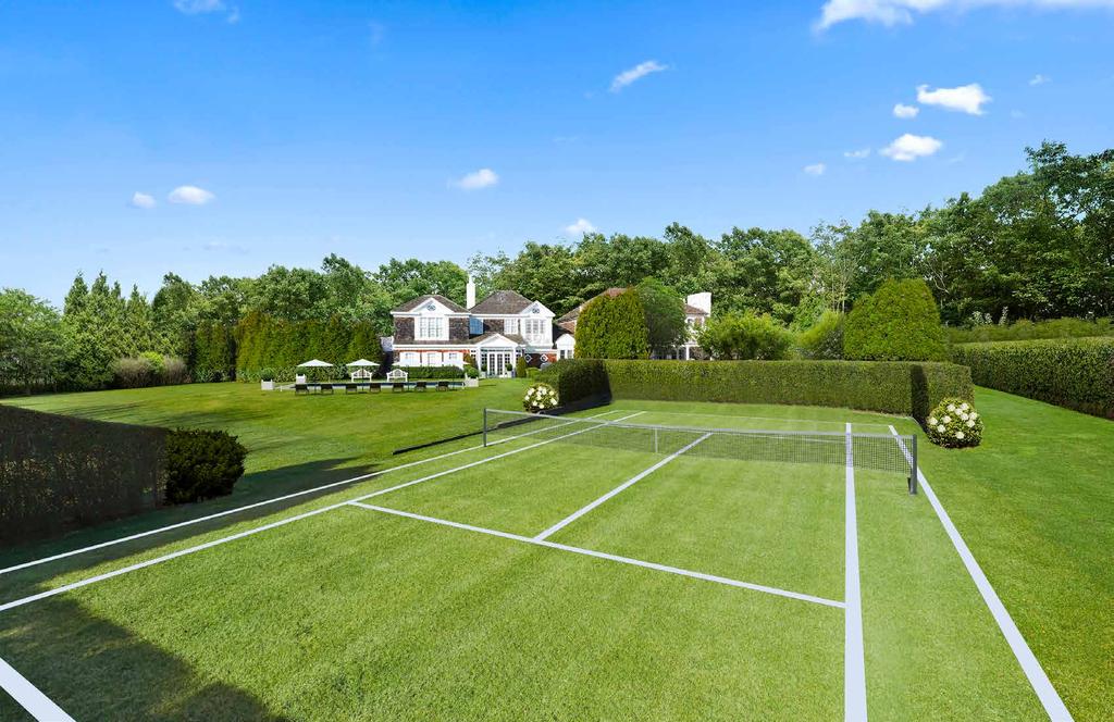 Back Exterior The back exterior features sprawling lawns and mature gardens, with a heated gunite swimming pool, a grass tennis court,