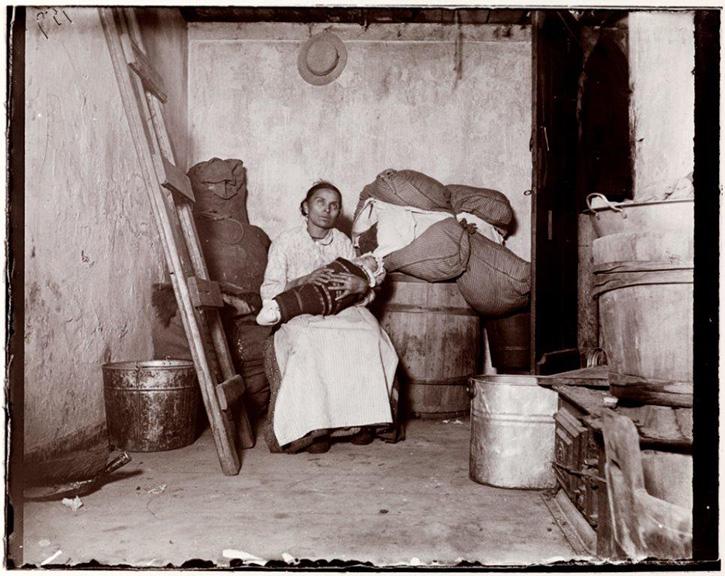Document C This image shows an Italian immigrant and her baby sitting in their windowless oneroom tenement.