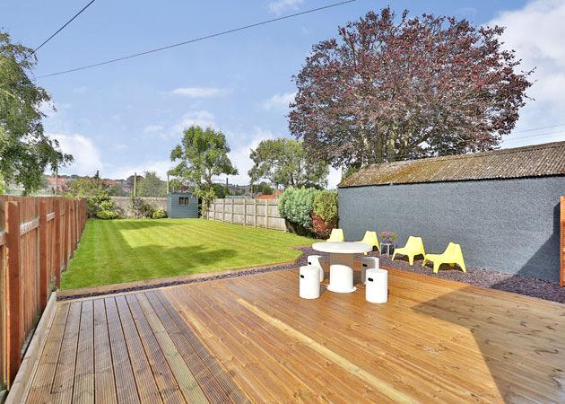 REAR GARDEN: Fully enclosed, the large Garden is mainly laid to lawn and boasts a decking area which is accessed via the sliding glass doors in the lounge. Garden shed, gate access to front.