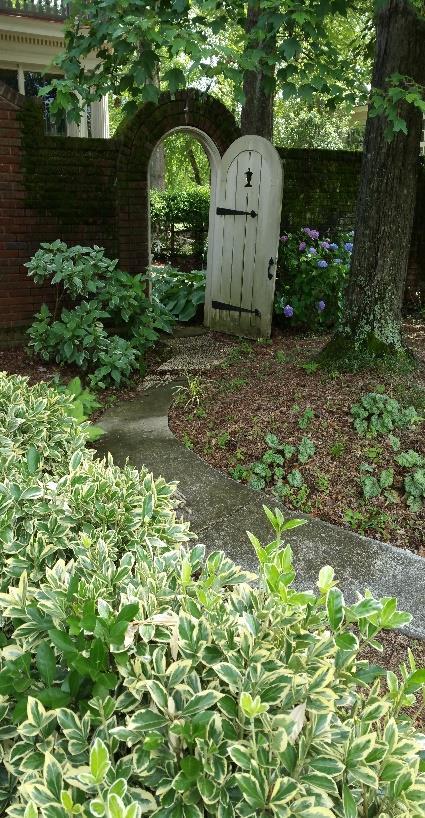 There is a brick archway to the back yard accessed along a pebble path lined with Hosta and ferns.