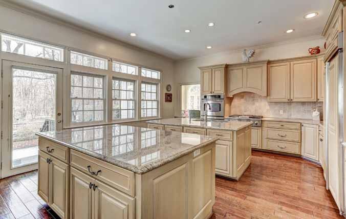 The enormous gourmet kitchen features two islands, granite countertops, stainless steel