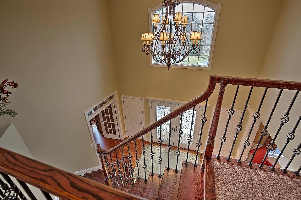 A mahogany flared staircase with iron balustrades, double French doors to the Living Room,