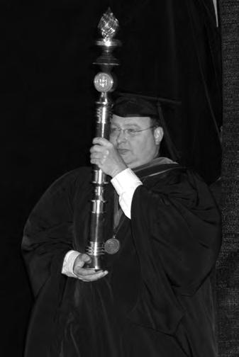 PRESIDENTIAL MACE CROWNED BY A FLAME symbolizing the Light of Knowledge, the Texas Tech University Presidential Mace is the symbolic staff of the power and authority of the university.