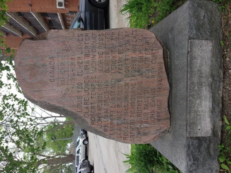 The stone features a Canadian maple leaf in a circle at the top, followed by a banner engraving, which states, Simcoe School War