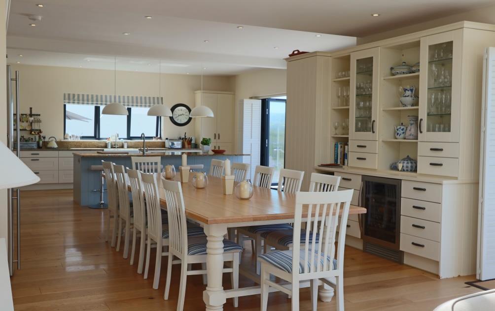 The extensively fitted kitchen comprises cream shaker style units with a contrasting pale blue