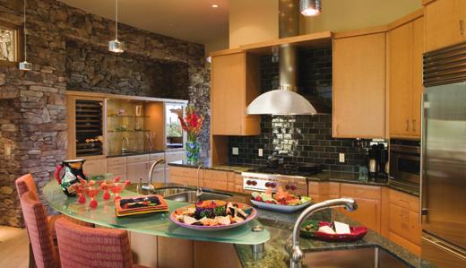 In the kitchen (above), a stone wall with built-in wine center is a rugged counterpoint to wood