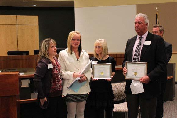 parents who received the award for him, presented by Lisa Secca (left) The