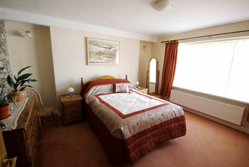 The accommodation is flexible with the central floor comprising a huge living room, a third bathroom and a kitchen/breakfast room which has access directly onto the rear garden and a large parking