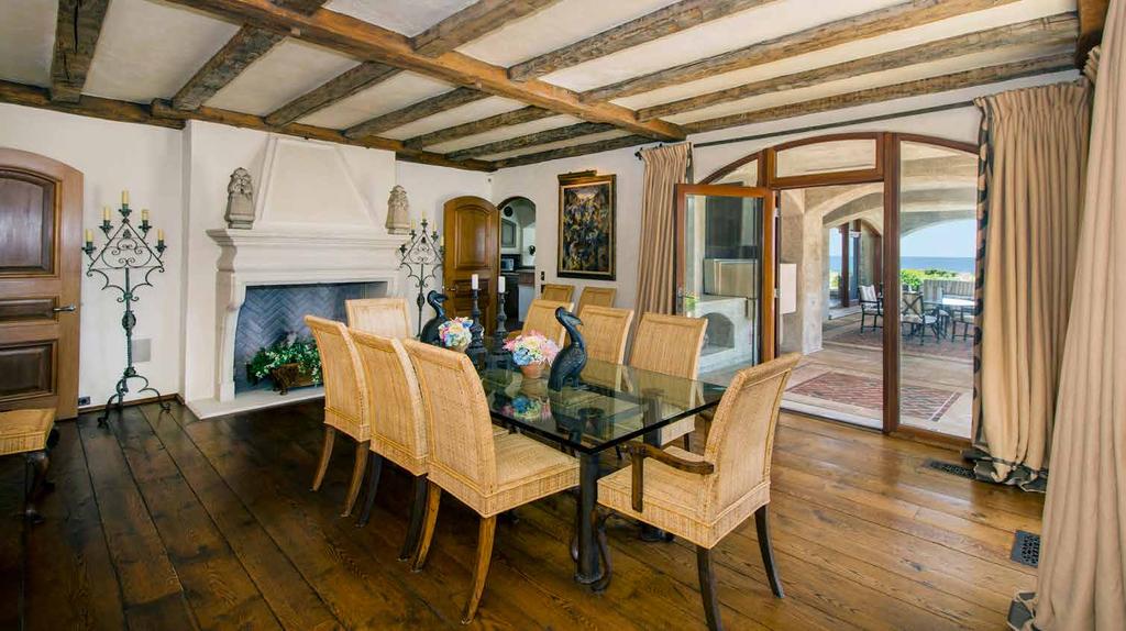 The formal dining room includes another fireplace and showcases the custom imported wood from a French