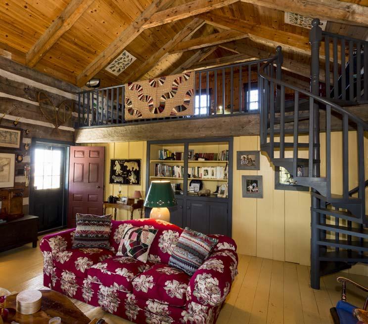 cabin has a large living room with high vaulted ceiling creating a loft area accessed via
