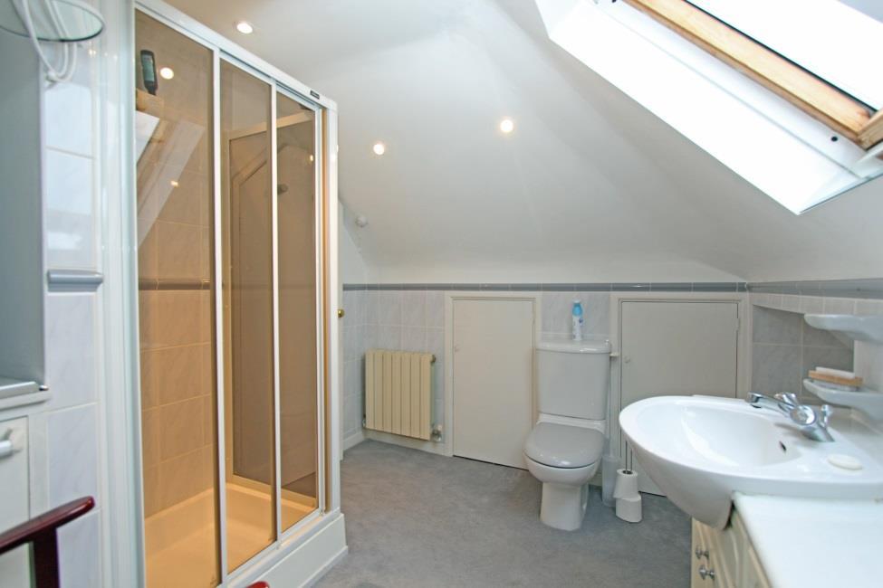 cubicle with sliding glazed shower screen, basin set in vanity unit with