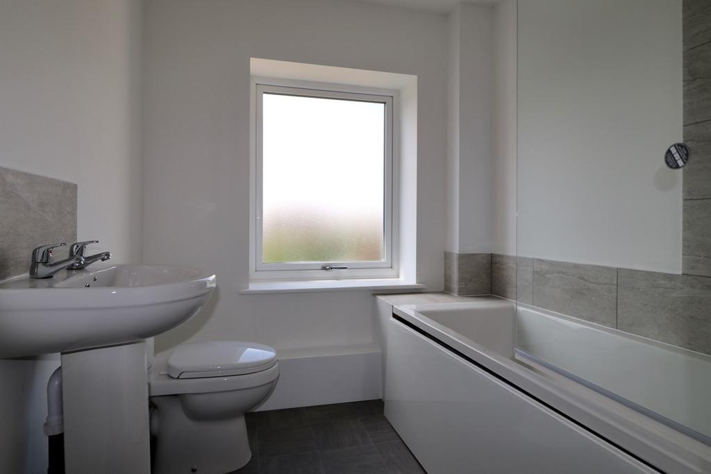 En-suite Shower Room Generously proportioned facility with low-level WC and pedestal basin in white. Light with integrated shaver socket. Corner shower cubicle with mixer.