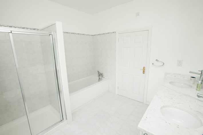 BATHROOM: White suite comprising: Panelled bath with mixer taps and shower fitting, shower cubicle