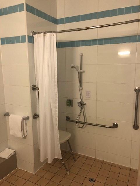 The shower dials are on a turn mechanism only in the partly accessible rooms. The bathrooms are well lit with wall lights and florescent tubes over the mirrors which are fully encased.