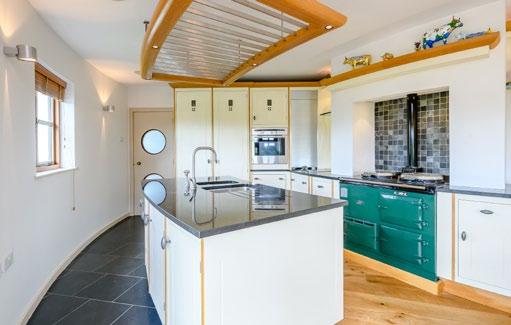 store, tall integrated fridge and adjoining larder. There is a matching island unit with 1½-bowl sink unit, integrated dishwasher and many storage cupboards beneath.