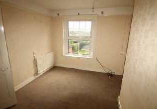appliances, a radiator, tiled flooring and a window to the rear. Bedroom One 3.01m x 3.
