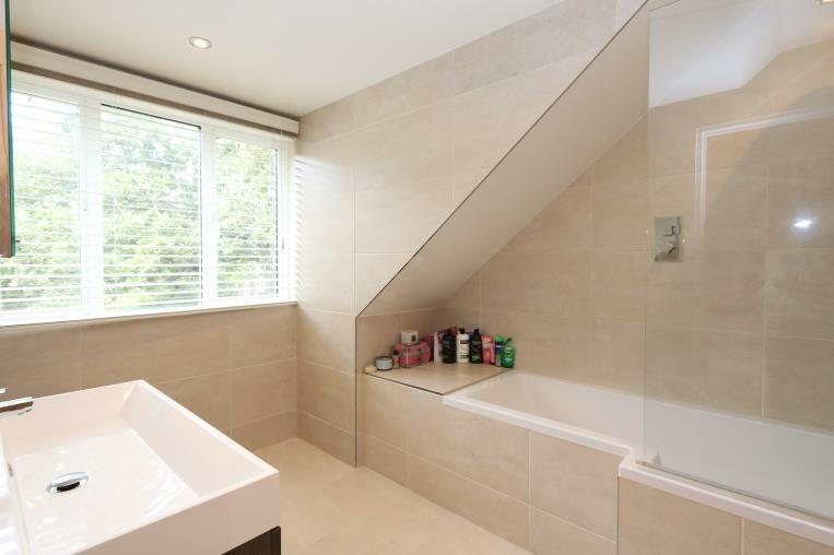 Dressing area with built-in wardrobes and door to: En suite bathroom 7 7 x 7 6 Fitted with a