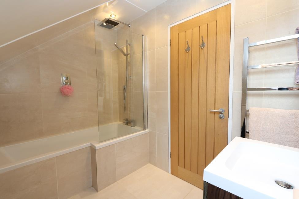 held shower heads, basin set in vanity unit with cupboard below and mirror fronted medicine cabinet