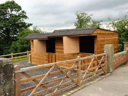 Post and rail fencing with access to timber stable block.