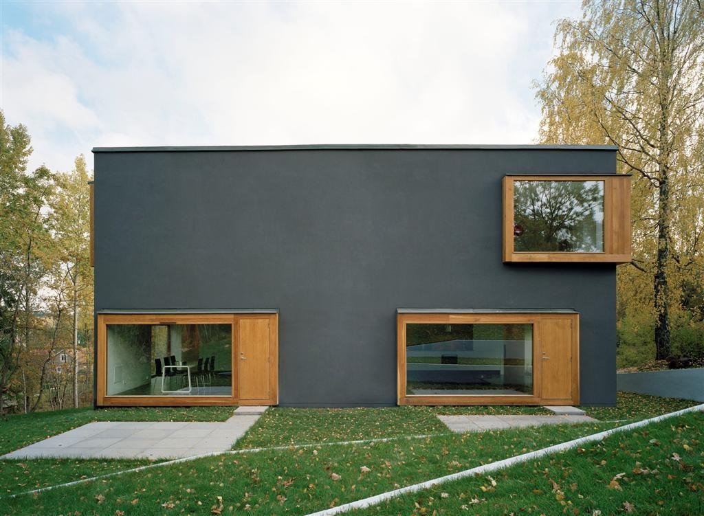 concrete Façades are rendered in plaster coloured dark greyish blue Protruding window boxes made of oak add a 3D quality to the façade, thus enhancing the depth and massive character of the interior