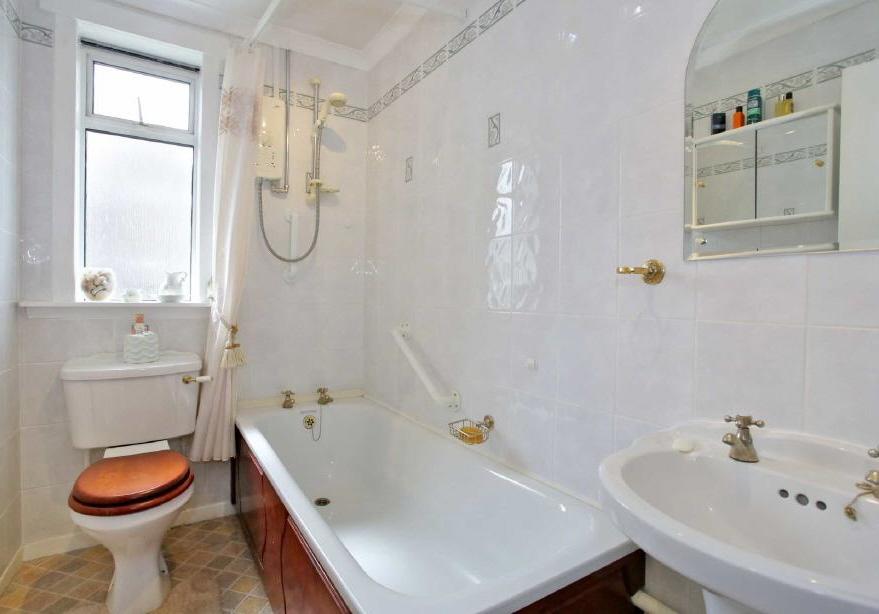 BATHROOM 8'0 x 4'11 (2.44m x 1.50m) Fully tiled and fitted with a white three piece suite comprising wash hand basin, toilet pedestal, and bath with shower over. Heated towel radiator.