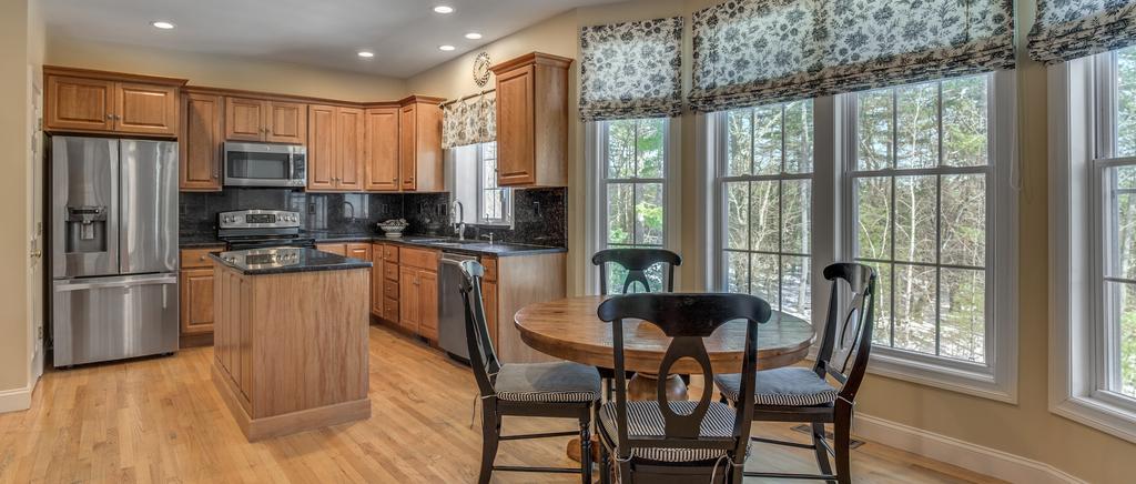 The updated kitchen has gleaming granite counters, rich cabinets, stainless steel