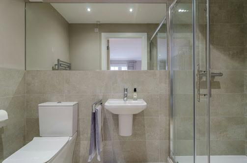 area. ENSUITE: Large corner shower unit with wet room finish, overhead Drencher showerhead, ceramic tiled floor and