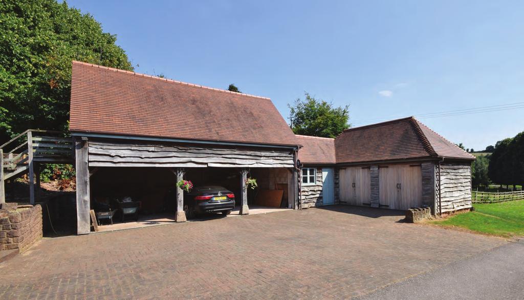 THE LARGE DETACHED GARAGE/WORKSHOP BLOCK WITH FLAT OVER A short distance from the house is a large detached garage/workshop block, built in 2000 of concrete block clad in Elm boarding, to match the