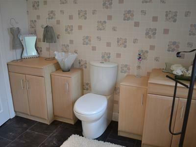 head, fully tiled with contrasting border, inset wash basin set into a vanity unit with