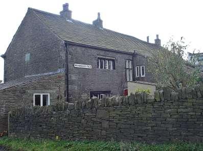 Brandwood Fold Farmhouse showing a plaque on the gable end commemorating the birthplace of Sir Thomas Barlow.