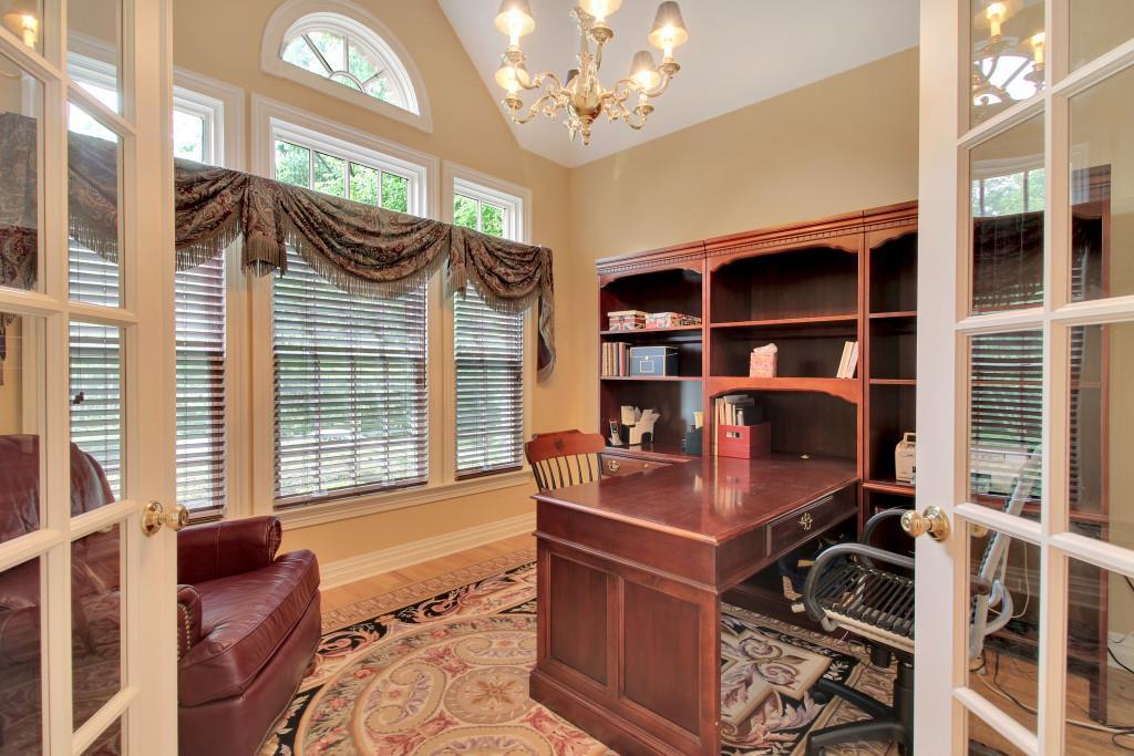 Dramatic columns, crown molding, and continuous hardwood flooring with inlays blend formality with warmth and
