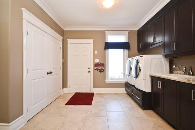 The laundry/mudroom is located near the kitchen. There is a door leading to the yard area as well as inside access to the triple car garage.