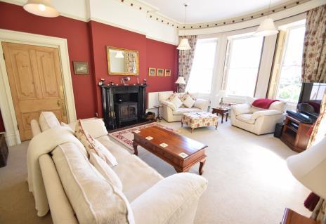 The living room interconnects with the kitchen/dining room and features an ornate period fireplace with wood burner and curved stone mullion sash windows creating the perfect ambience to relax with