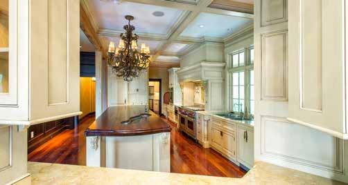 Custom built-in cabinetry surrounds a large stone fireplace and includes a motorized TV lift.