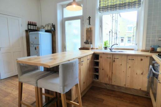 The kitchen features bespoke constructed work surfaces and cupboards made with reclaimed wood.