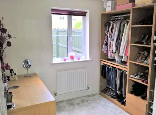 The hall offers excellent storage space with its two cupboards at opposite ends. With wood laminate flooring and double radiator.