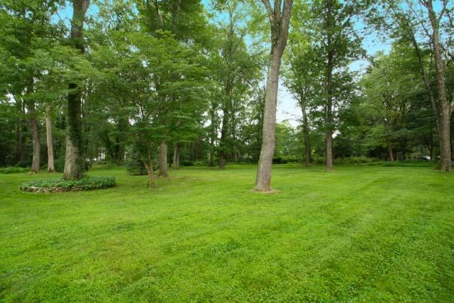 Enjoy over an acre of level park-like land crowned