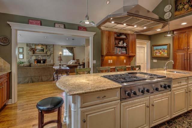 This extraordinary gourmet kitchen features a 10 ft granite center isle with seating for 6, custom featured cabinetry in natural