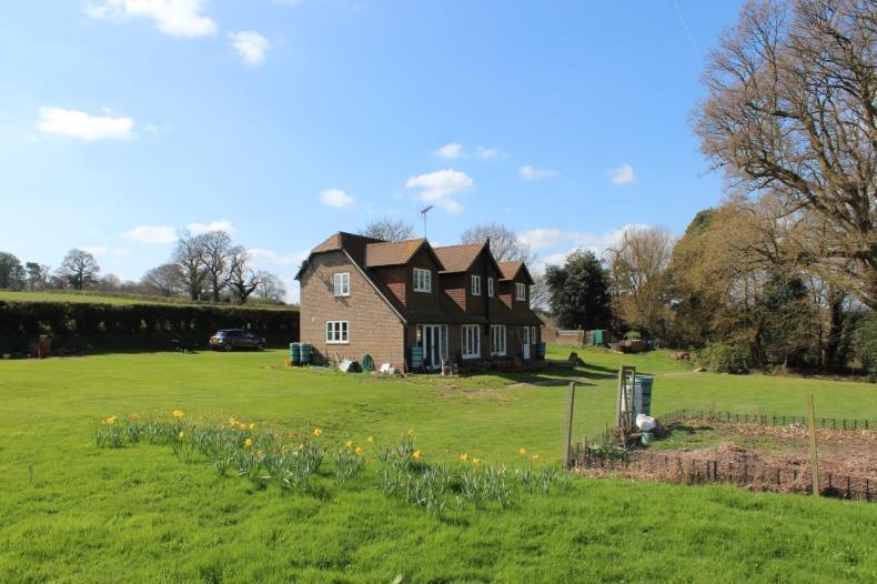 countryside views to the rear. Further benefits include under floor heating throughout and character features such as exposed beams and a wood burner within the reception rooms.