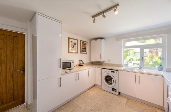plumbing for a washing machine, space for a dryer, wall mounted boiler, marble flooring, double glazed window to the rear, door leading into the garage and a central heating radiator.