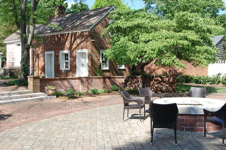 Mature trees provide ample shade in the warm summer months, and a built-in fire pit provides warmth in the winter.