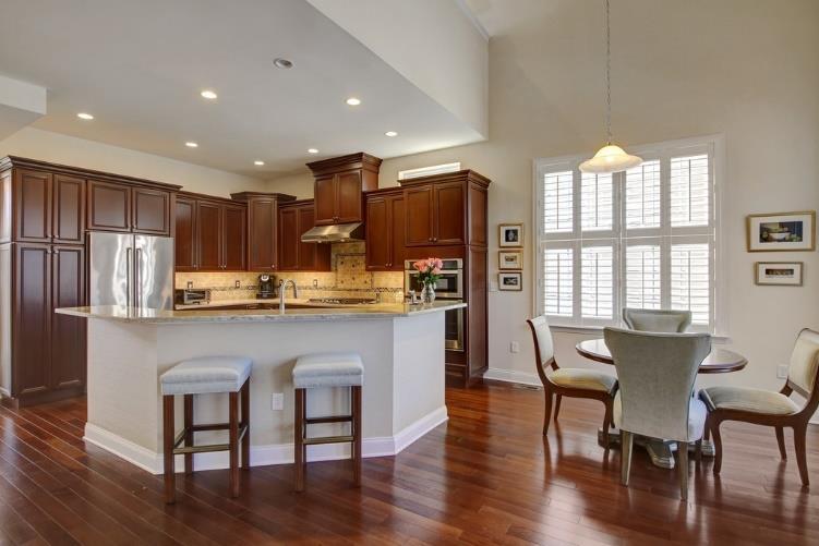 The granite countertops, subway tile backsplash, Listello accent tiles, hardwood floors and cherry hued cabinetry are