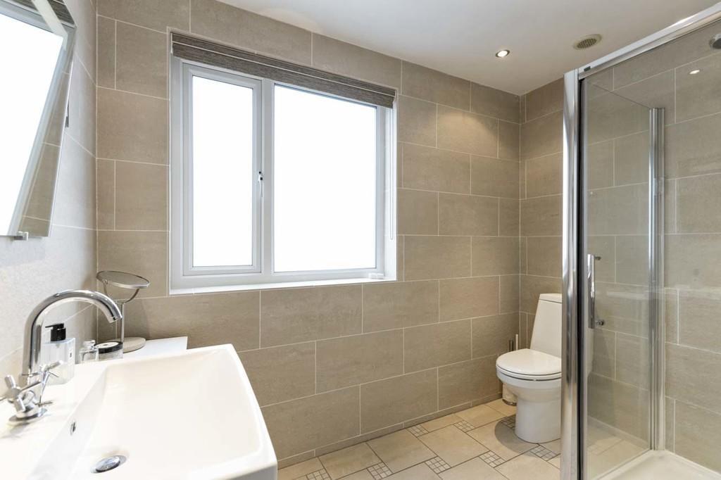 EN-SUITE SHOWER ROOM Modern white suite comprising low flush w.c. Floating wash hand basin with mixer tap.