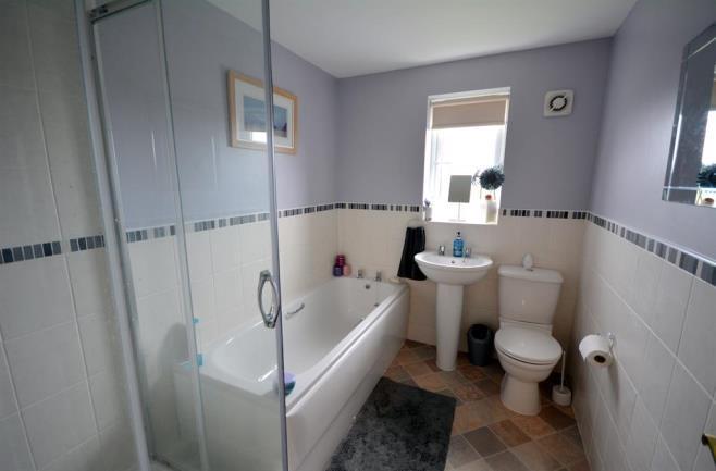 BATHROOM Family bathroom which is fitted with a contemporary suite that comprises of a shower cubicle, panelled bath with perimeter tiling, wash hand basin and WC. Opaque window to the rear elevation.